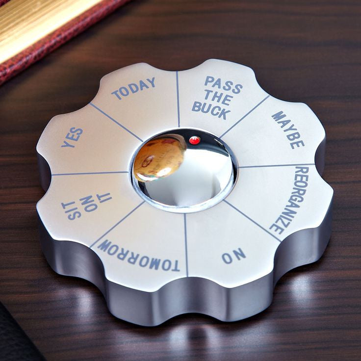 Silver desktop decision maker with humorous options including yes, no, maybe and pass the buck