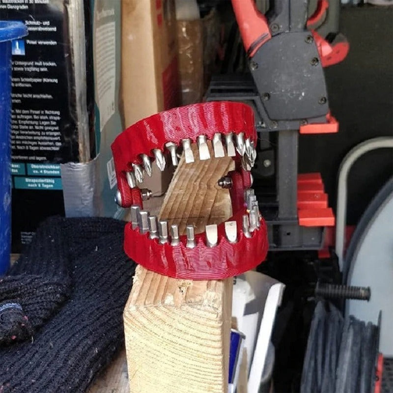 A drill bit storage holder in the shape of dentures where drill bits can be stored in the place of teeth. The holder is in use in a workshop.