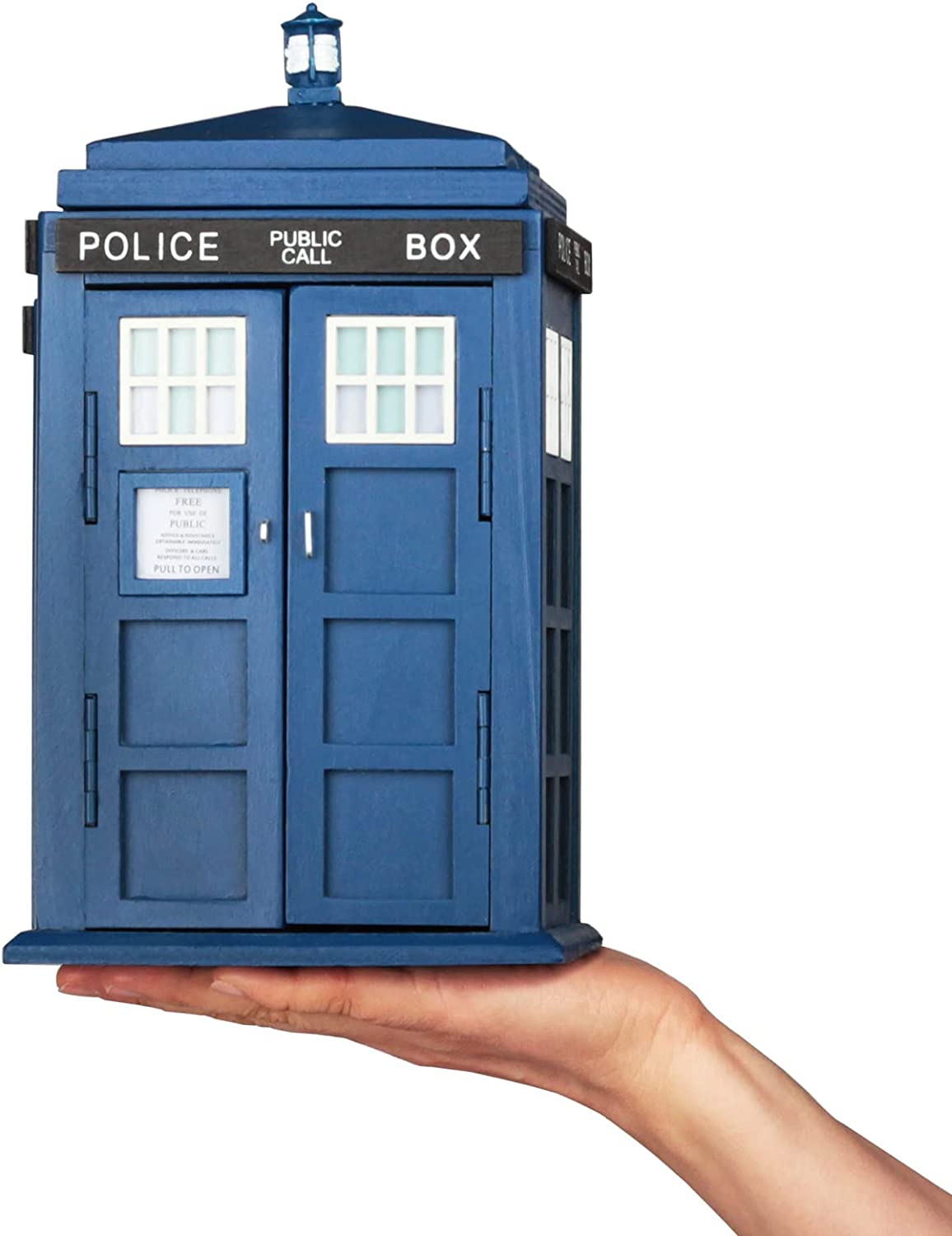 A storage box shaped like the Tardis sitting on the palm of a persons hand.