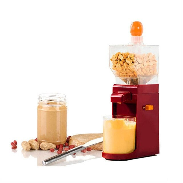 An electric peanut butter maker filled with peanuts with a jar underneath the spout. There is a glass jar of peanut butter next to the machine.