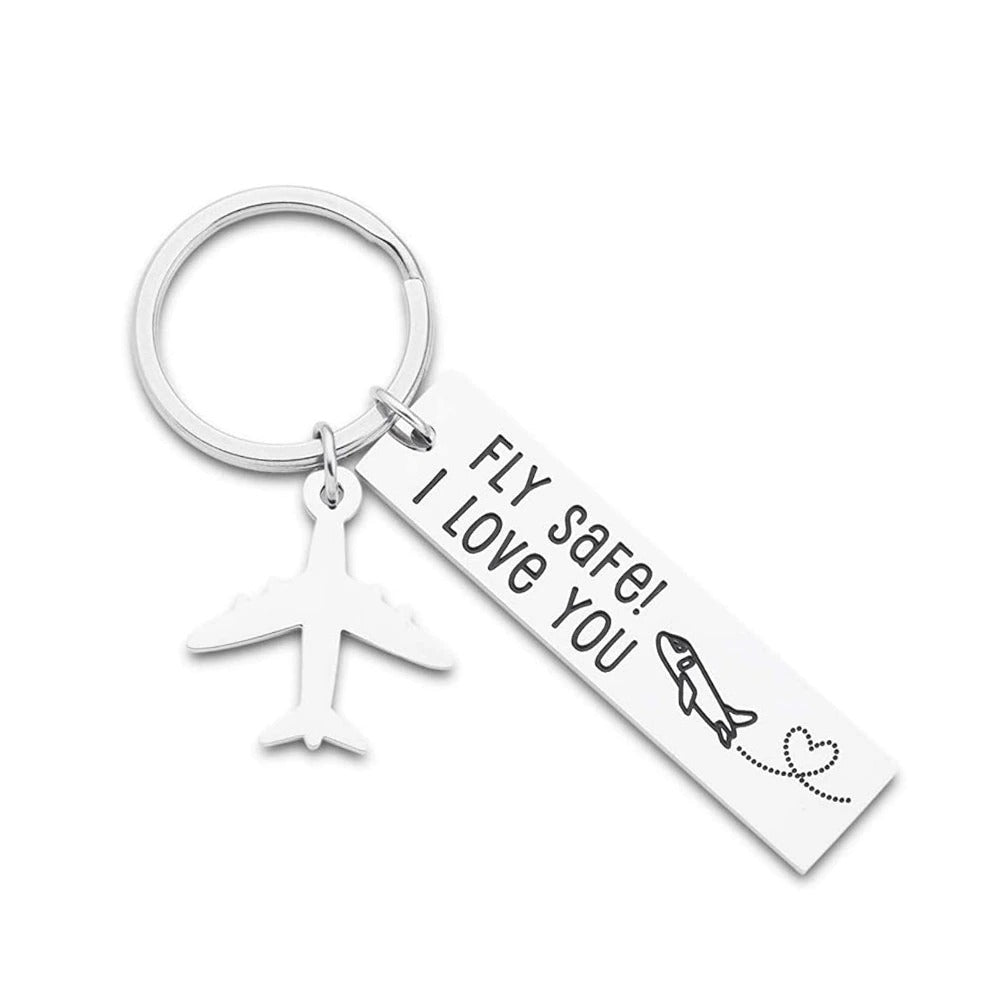 A silver keychain which has a tag that reads, fly safe, I love you. There is an airplane pendant attached to the keyring as well.