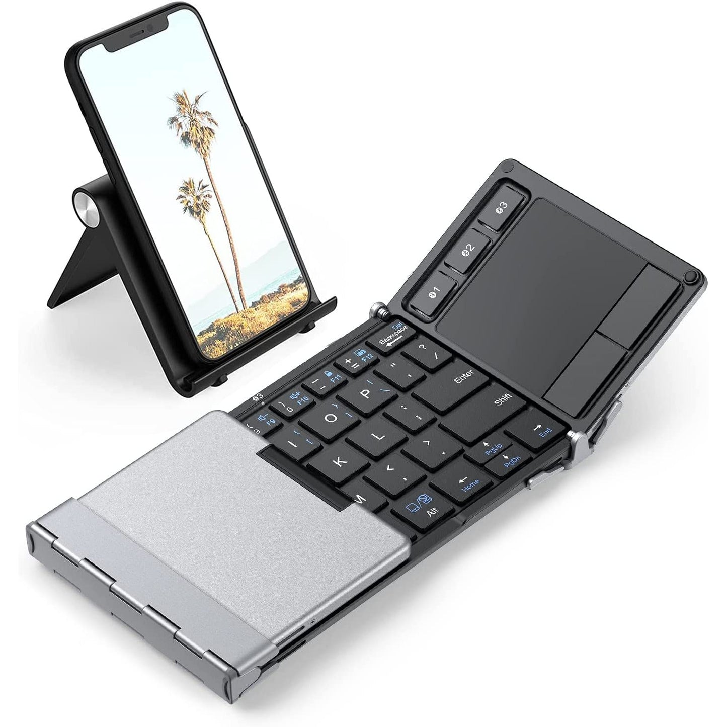 A Bluetooth foldable keyboard with one side folded over and the other side closed. There is a cell phone behind the keyboard.