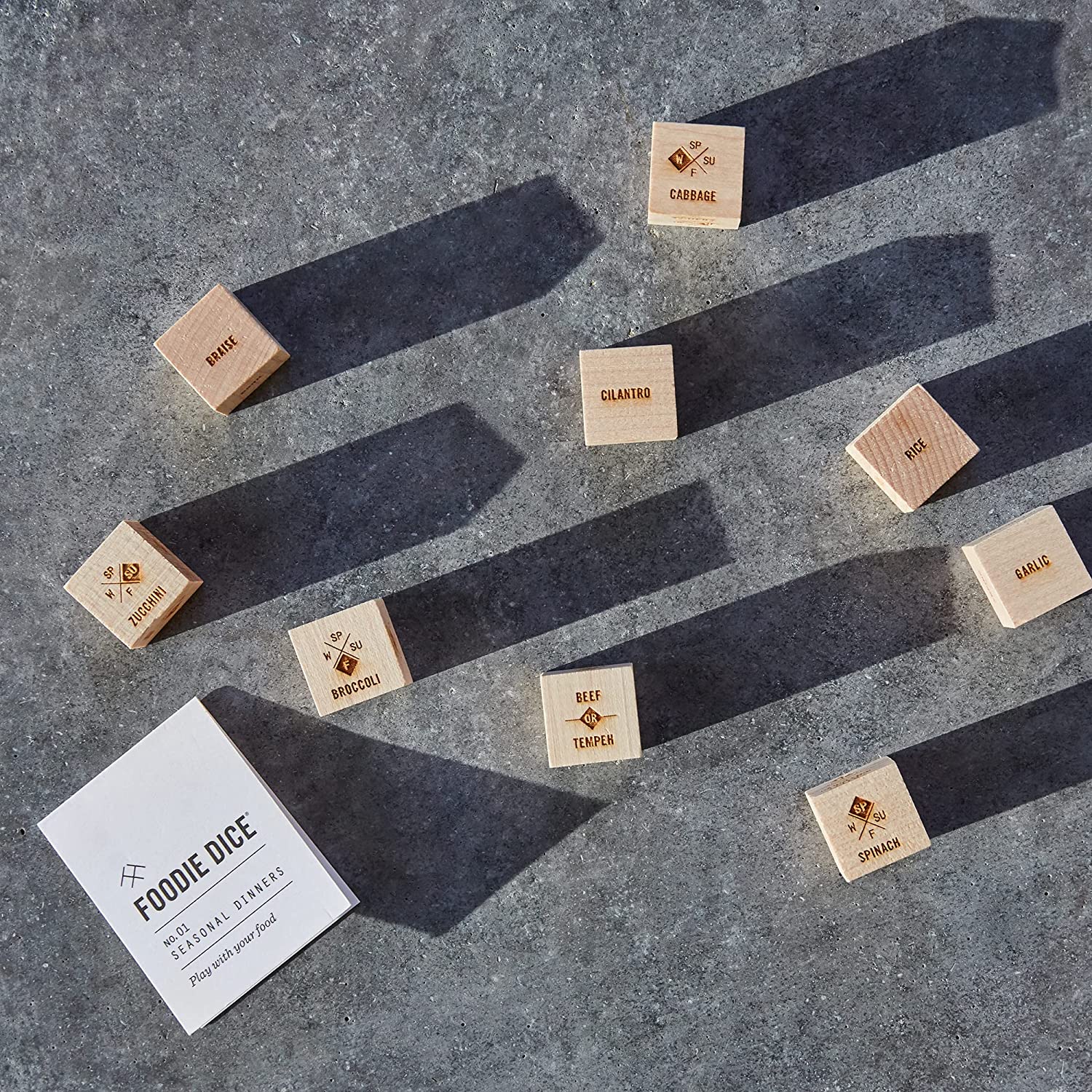 A product called Foodie Dice which helps you decide what to cook for dinner by throwing a set of dice. There is an instruction book nearly and a number of wooden foodie dice as well.