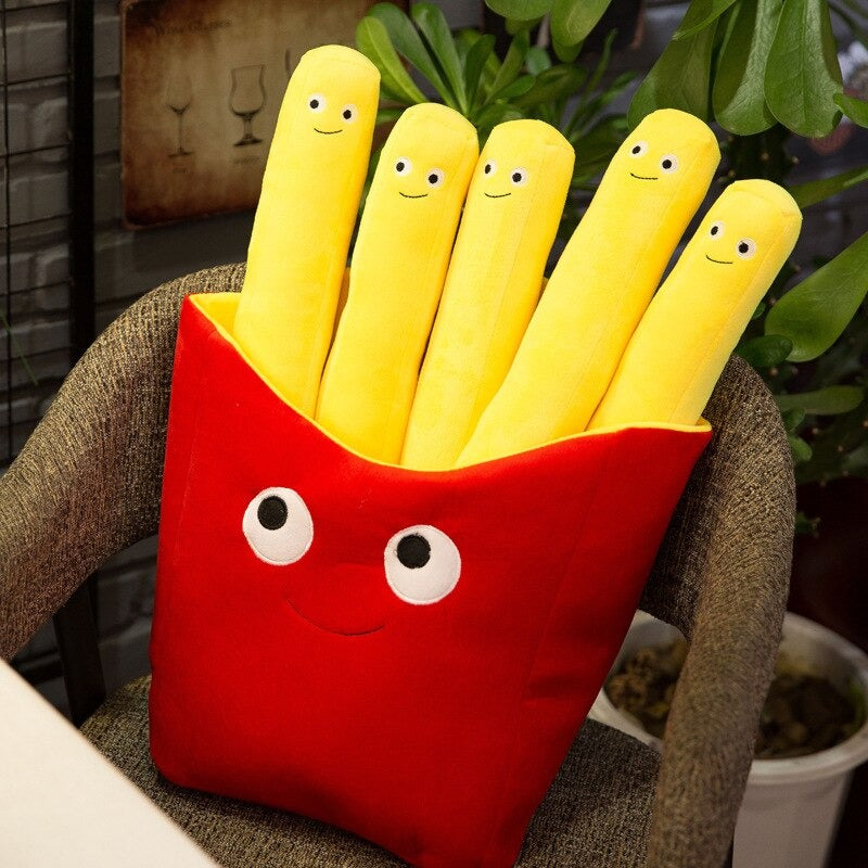 Six pillows shaped like French fries which all have smiley faces on them. The fries sit inside a smiling red fry holder container.