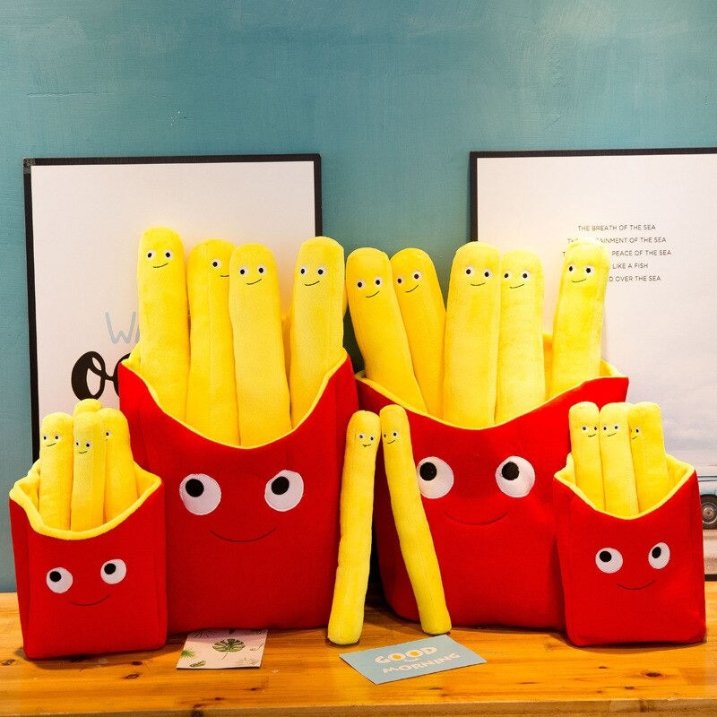 Four lots of French fry cushions. This includes yellow pillows shaped like French fries which all have smiley faces on them. The fries sit inside red fry holders with smiley faces.