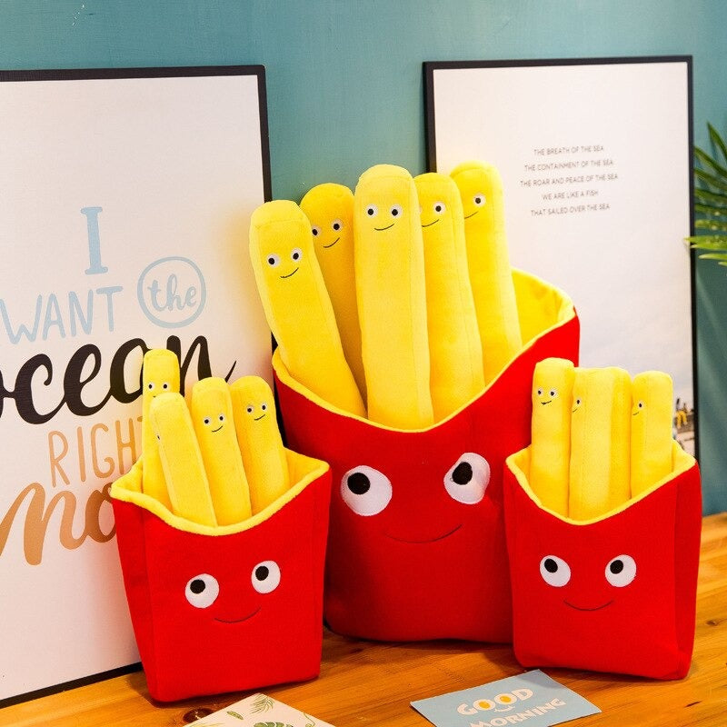 Cute and adorable yellow cushions shaped like French fries which all have smiley faces on them. The fries sit inside red fry holders with smiley faces on them..