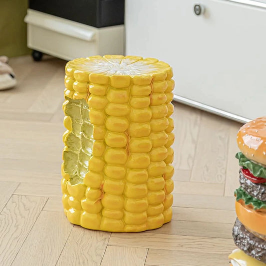 A giant cob of corn which is a stool. It looks like a bite has been taken out of the side.