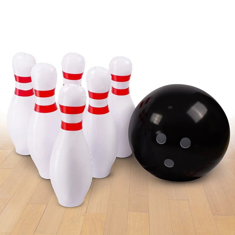 A giant inflatable outdoor bowling set which is setup on a white background and floorboards. It consists of six giant pins and an inflatable bowling ball.