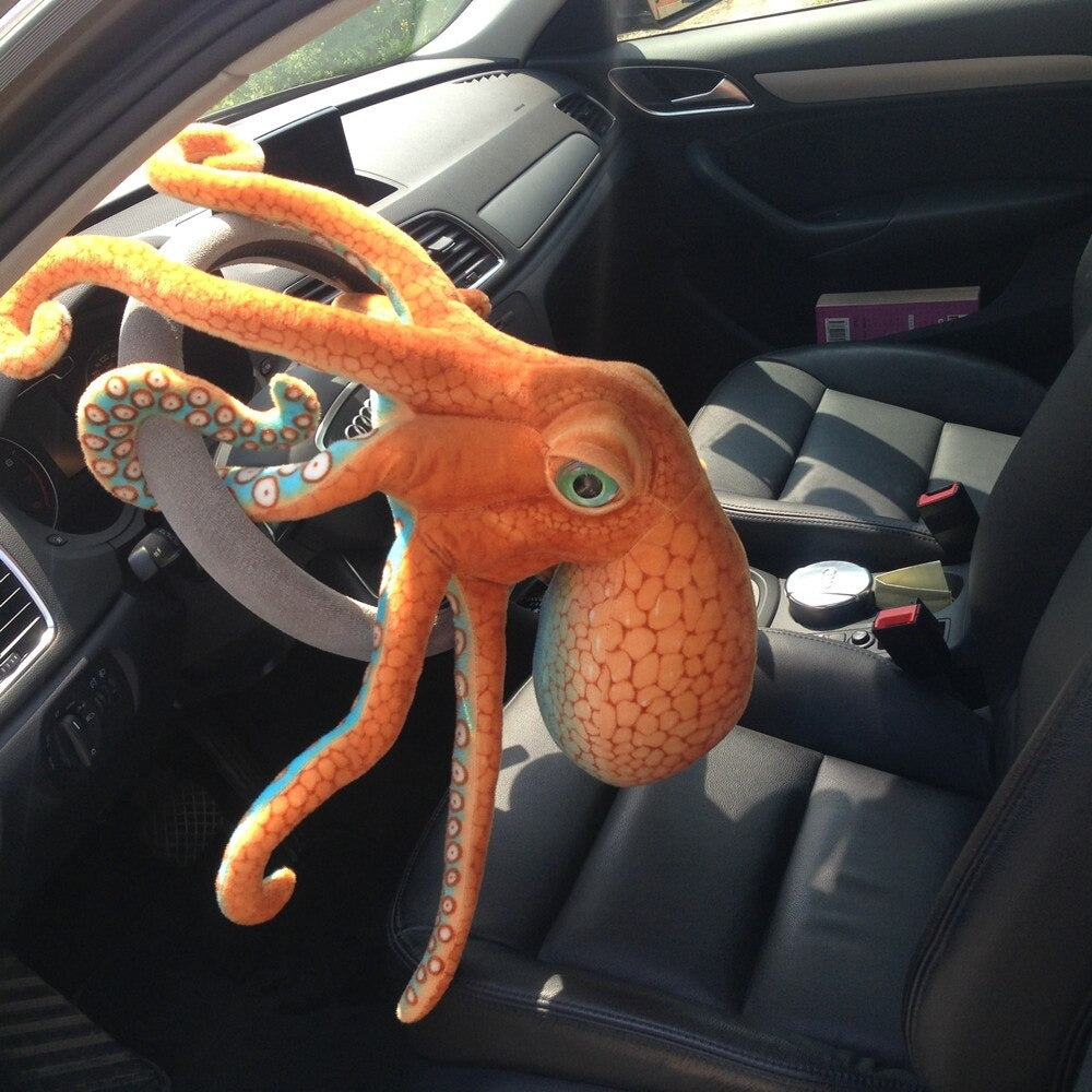 A octopus plush toy inside a car wrapped around the steering wheel