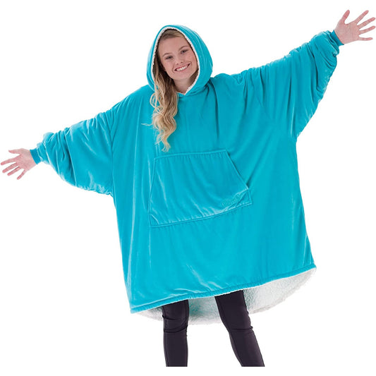 A woman is smiling with her arms out while wearing an aqua colored oversized blanket.