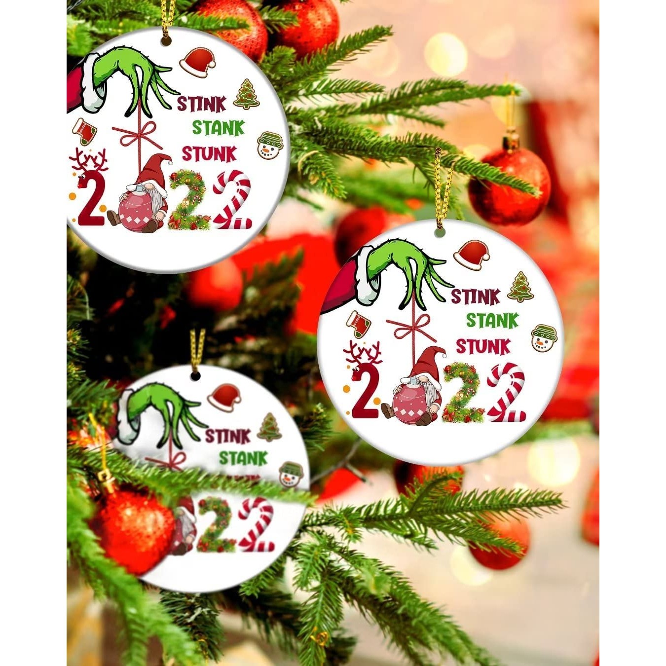 Three Grinchy Christmas tree ornaments which all say, 'Stink, stank, stunk 2022' on them.