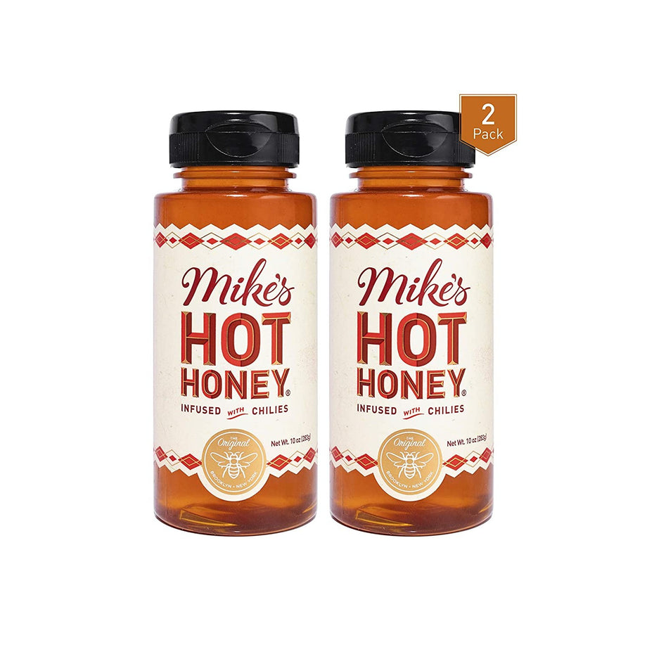 Two bottles of chili-infused hot honey with orange labels and black caps