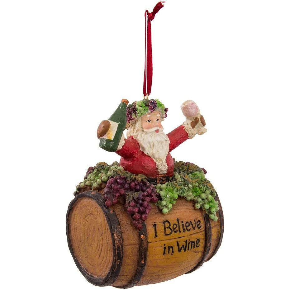 A Christmas tree decoration of Santa holding a wine glass and bottle. Santa is on a wine barrel which reads, "I believe in wine."