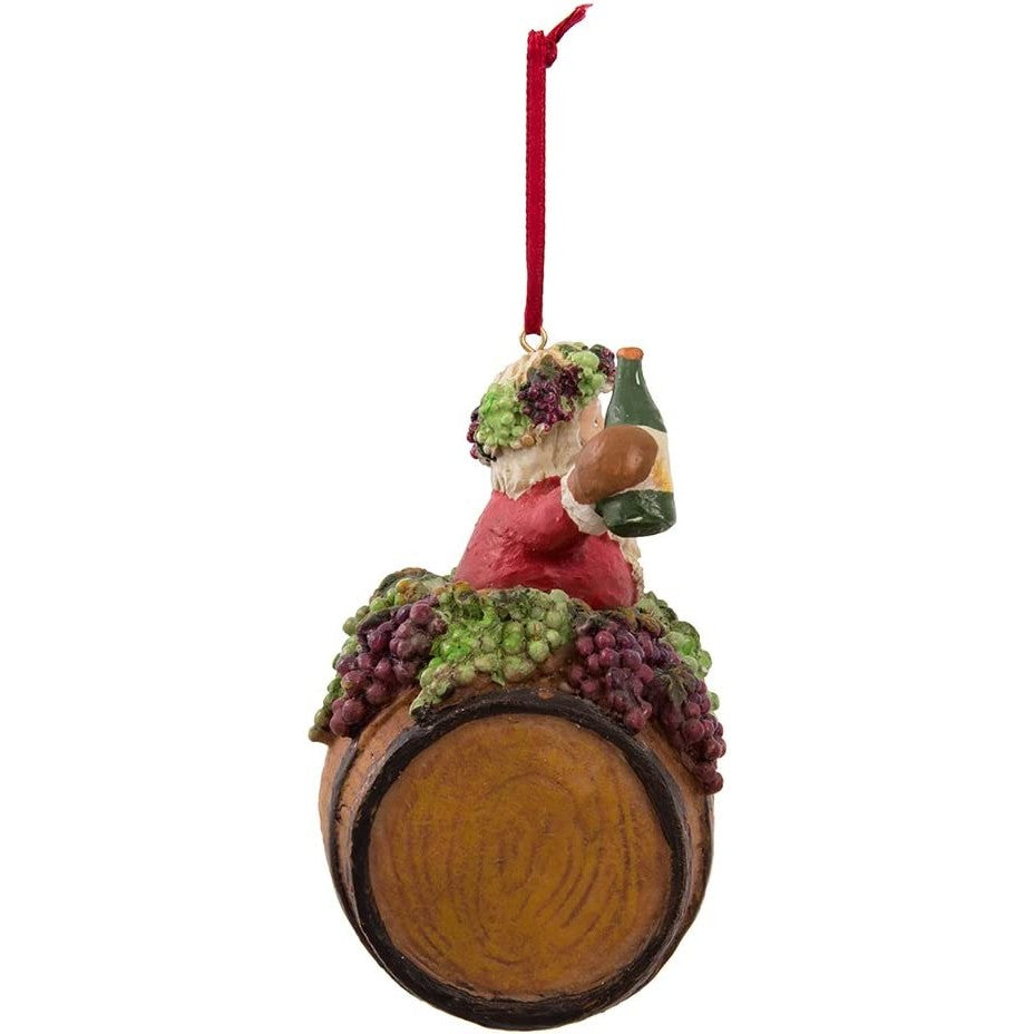 A side view of a Christmas tree ornament which features Santa on a wine barrel while holding a wine bottle and glass.