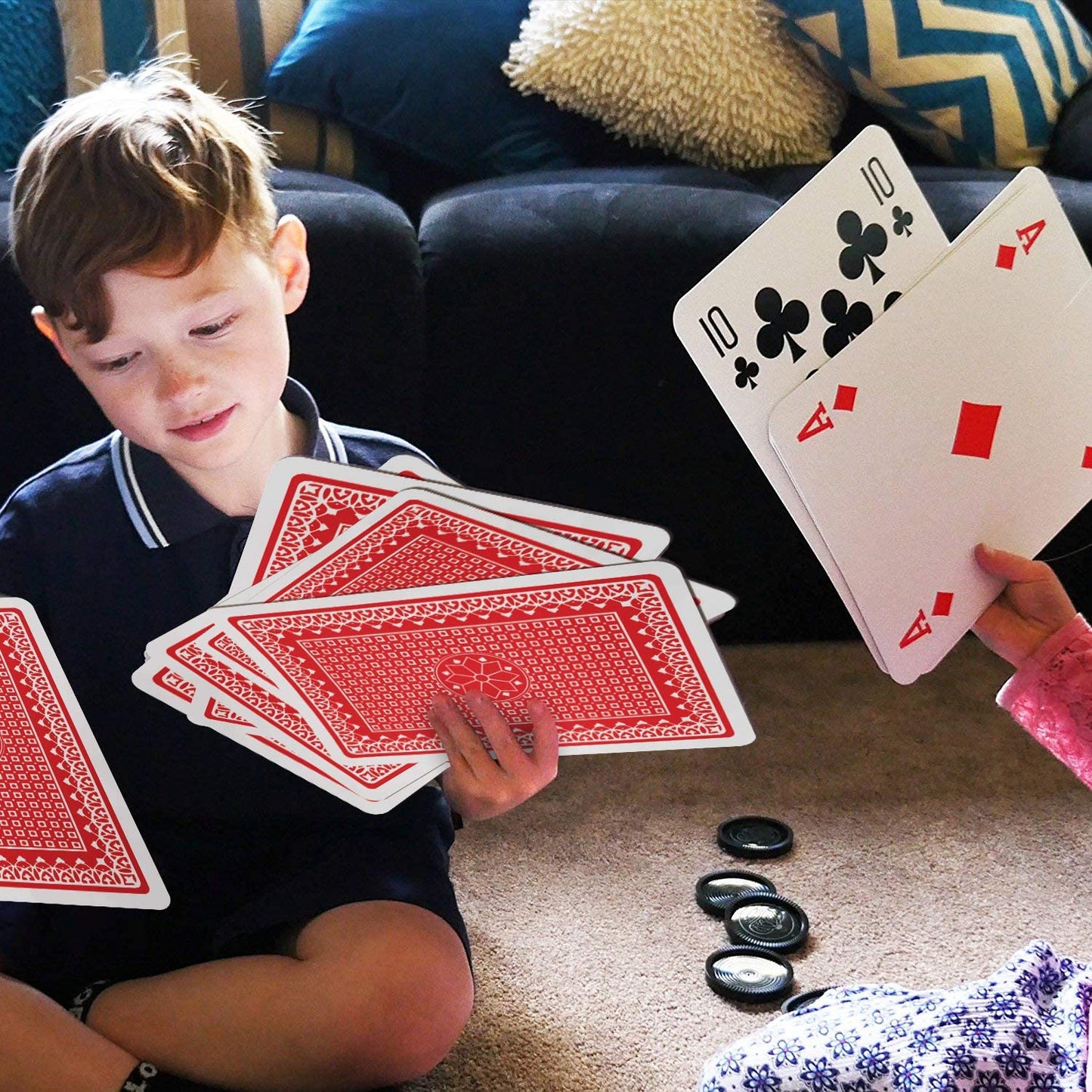 A child holding a couple of jumbo sized playing cards.