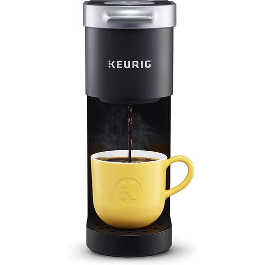 A black Keurig K-Mini coffee maker with fresh coffee flowing into a yellow cup 