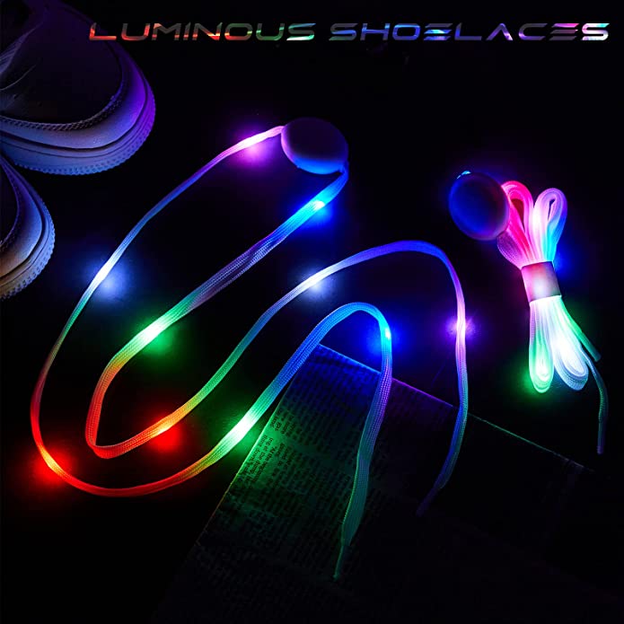 A pair of LED light up shoe laces are on a black background. The laces are glowing multi-colored.