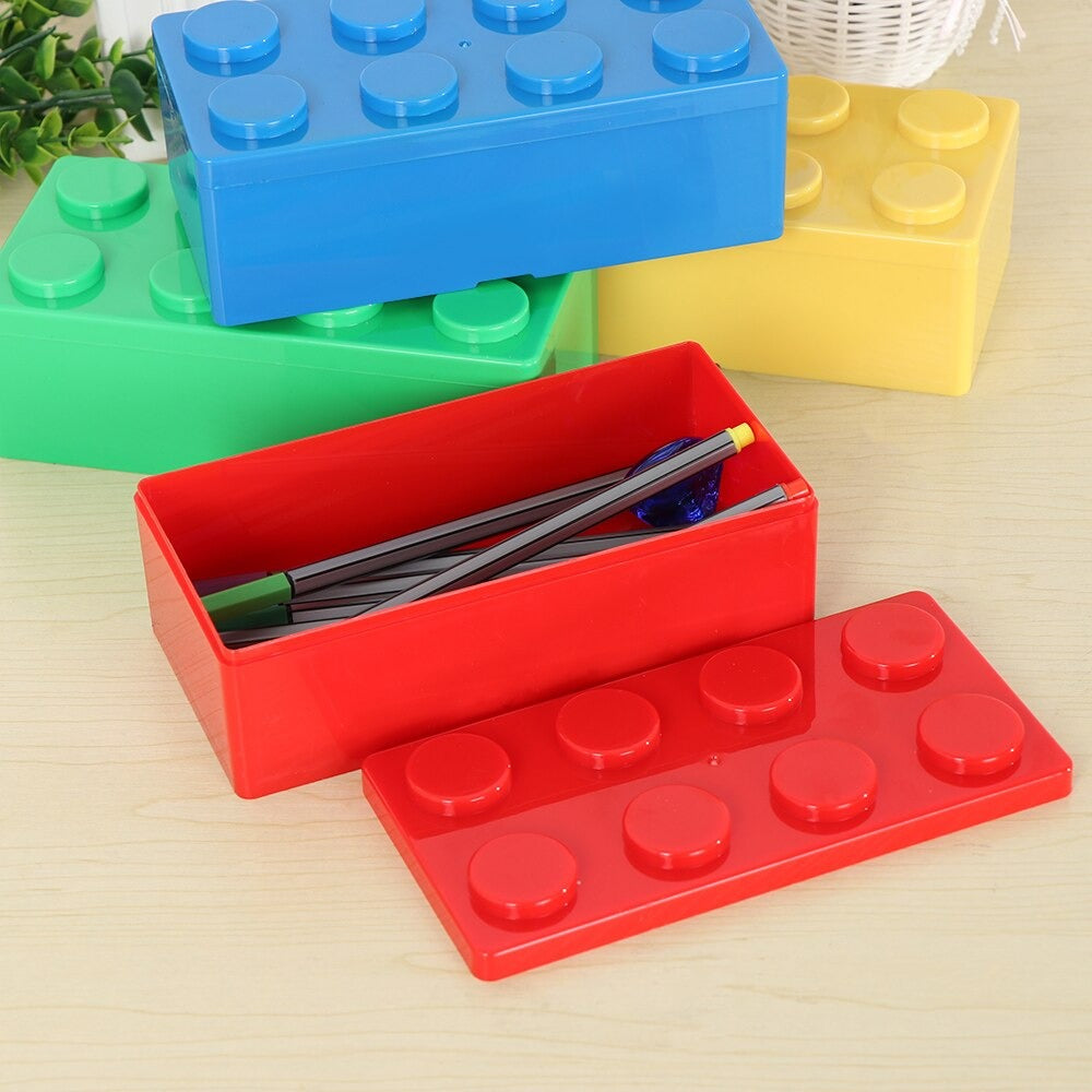 Four rectangular storage boxes which look like super-sized Lego pieces in various colors. One storage box is open and filled with pens.