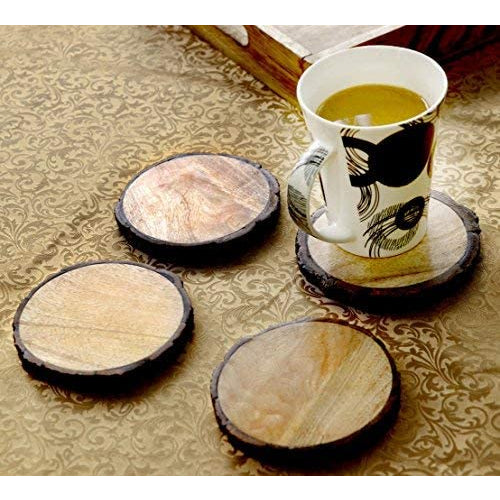 4 wooden mango tree coasters. A cup of tea is sitting on one of the coasters.