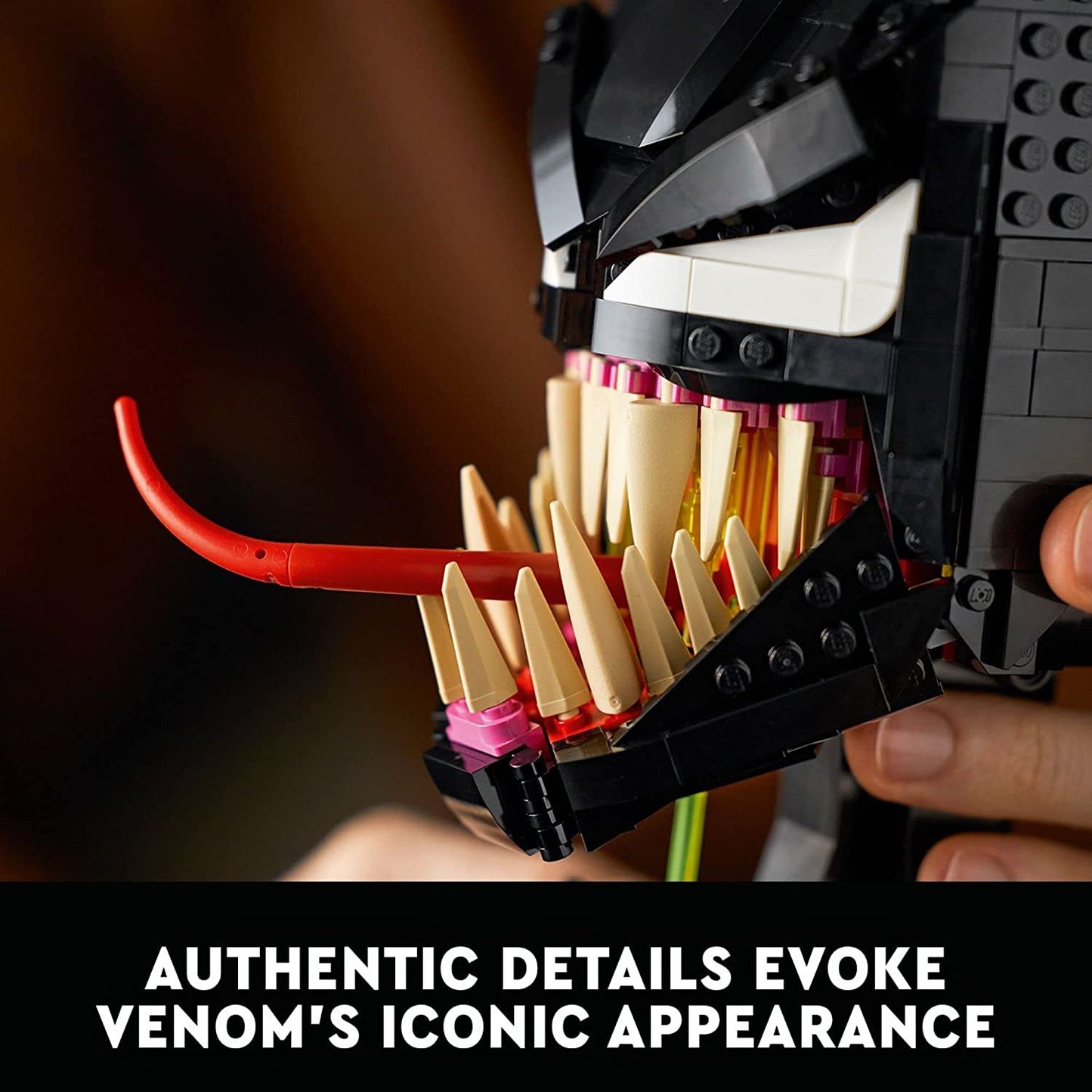 A close-up view of the face of a fully complete Venom Lego building set. The text reads, "Authentic details evoke Venom's iconic appearance."