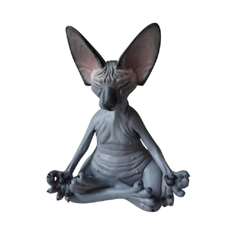 A solitary meditating Sphynx toy cat sitting in a yoga pose with its legs crossed and fingers pinched as if it is meditating. The cat is colored grey.