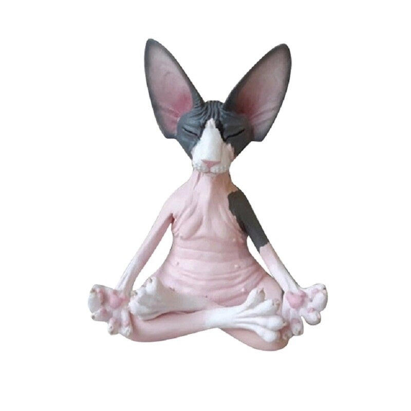 A solitary meditating Sphynx toy cat sitting in a yoga pose with its legs crossed and fingers pinched as if it is meditating. The cat is colored grey and pink.