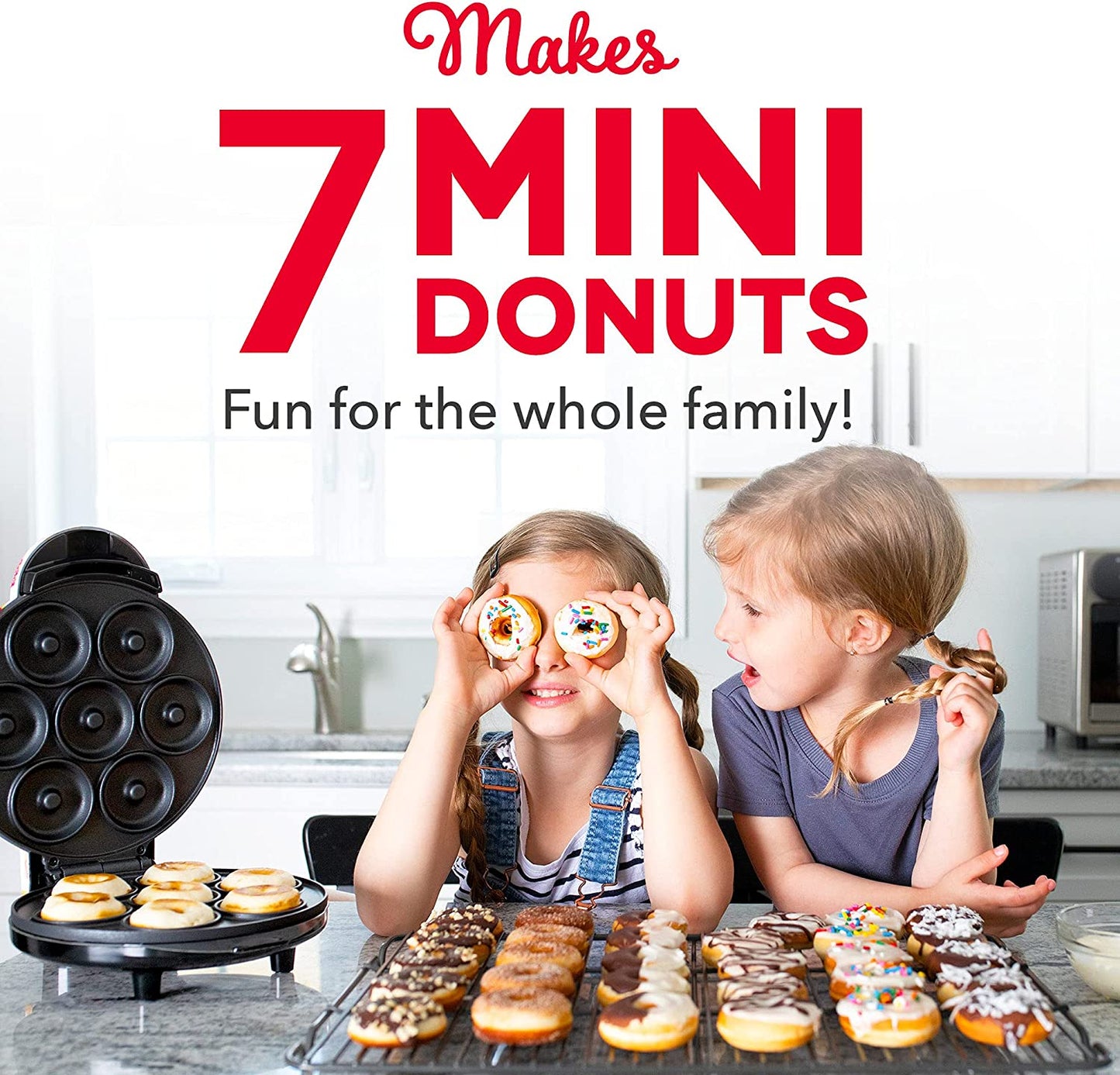 Two children are in a kitchen with a large amount of donuts in front of them. There is also a mini donut machine. The text says, Makes 7 mini donuts. Fun for the whole family.'