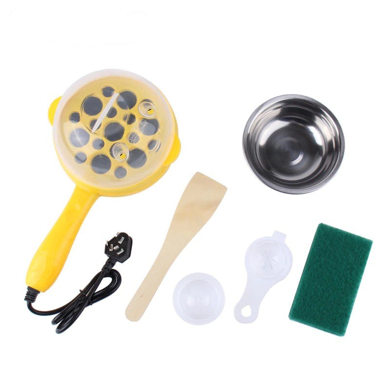 A multi function mini egg cooker with accessories that come with the cooker, including a spatula, bowl, and cleaning utensils.