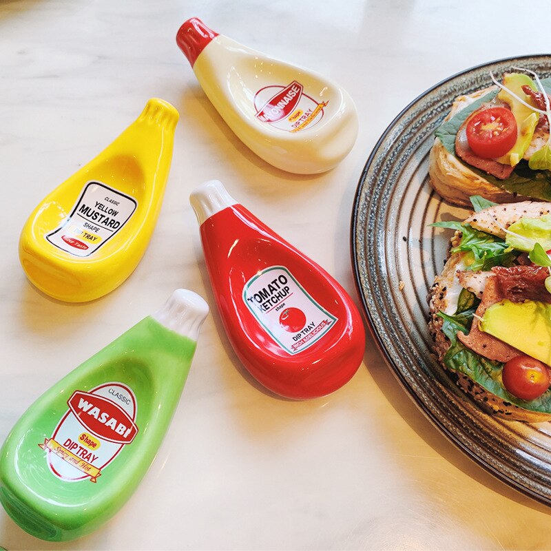 Four dipping sauce bowls which look like mini versions of larger brand sauce bottles. These include tomato sauce, mayo, wasabi and yellow mustard and are used for finger food.
