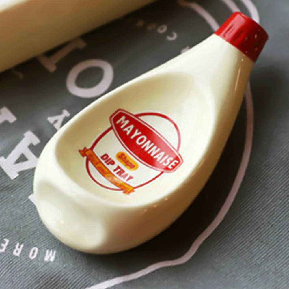 A close-up view of a sauce dipping bowl which looks like a miniature version of mayonnaise. The bowl is used to hold dipping sauce. 