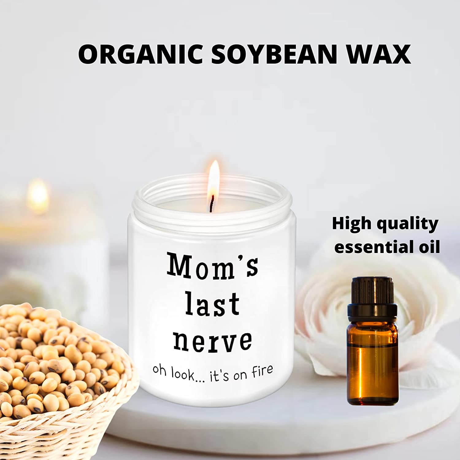 A white candle in a jar, there is text on the candle jar which says, 'Mom's last nerve, oh look... its on fire.' There is also a small brown bottle which says, 'High quality essential oil.'