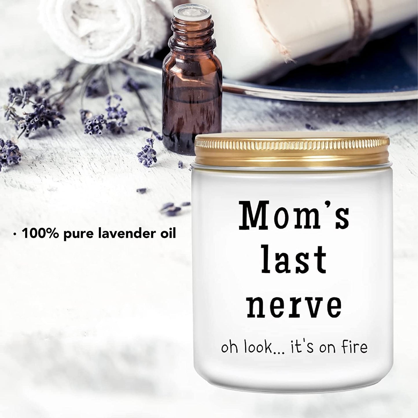 A funny white soy candle in a jar which says, 'Mom's last nerve, oh look... its on fire.' There is also a small brown bottle with text that says, '100% pure lavender oil.'