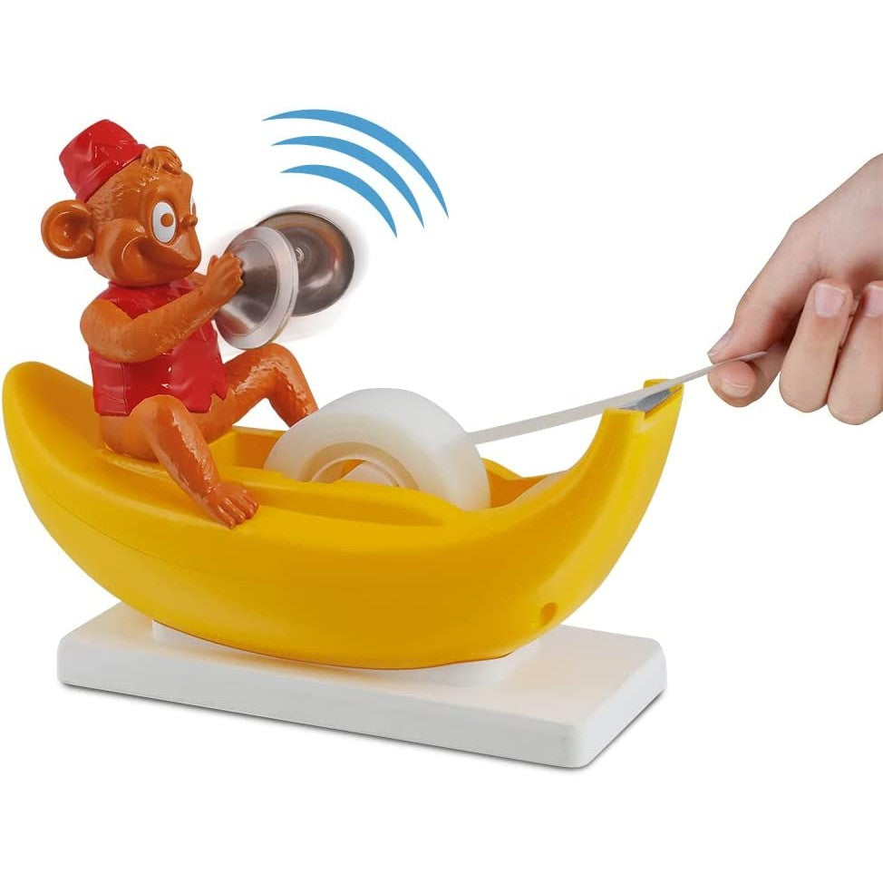 Novelty monkey tape dispenser sitting in a banana-shaped holder