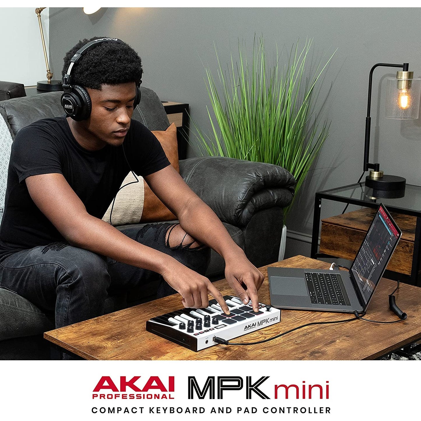 A person is using an AKAI MPK Mini MK3 with a laptop.