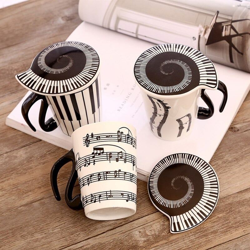 3 music inspired mugs with music inspired lids. All the mugs features images of music such as piano keys and musical notes.