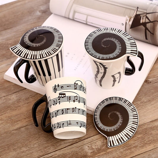 3 music inspired mugs with music inspired lids. All the mugs features images of music such as piano keys and musical notes.