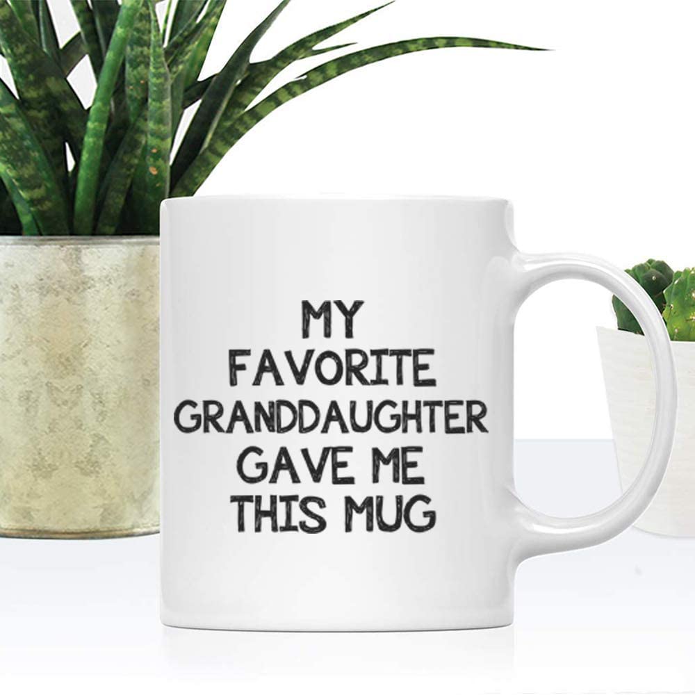 A white coffee mug on a white table with words printed on the mug that says, 'my favorite granddaughter gave me this mug'
