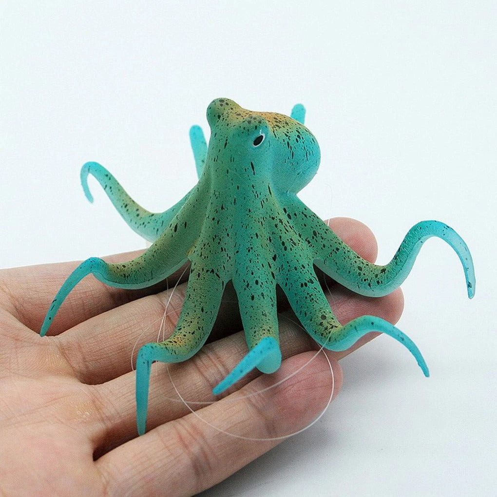 A green colored fluorescent octopus ornament in the palm of a hand.