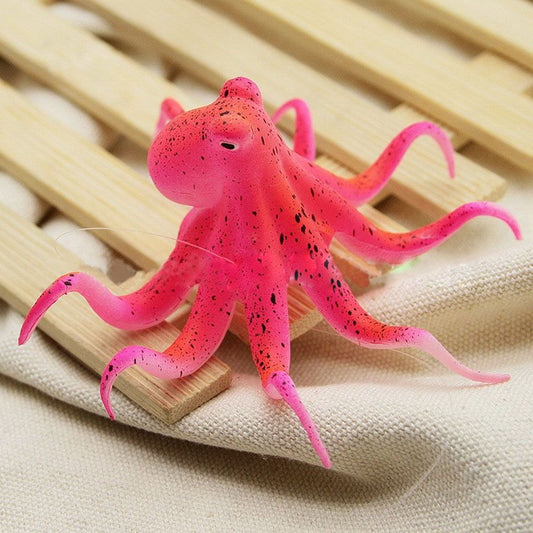 A pink colored fluorescent octopus aquarium ornament.