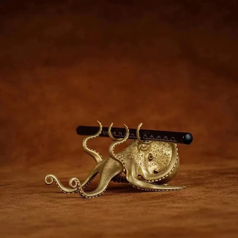 An octopus shaped mobile phone holder holding up a phone.