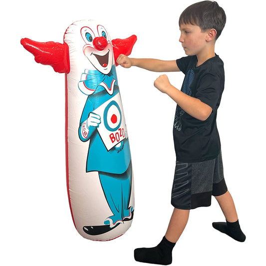 A boy is punching an original Bozo the clown bop bag.