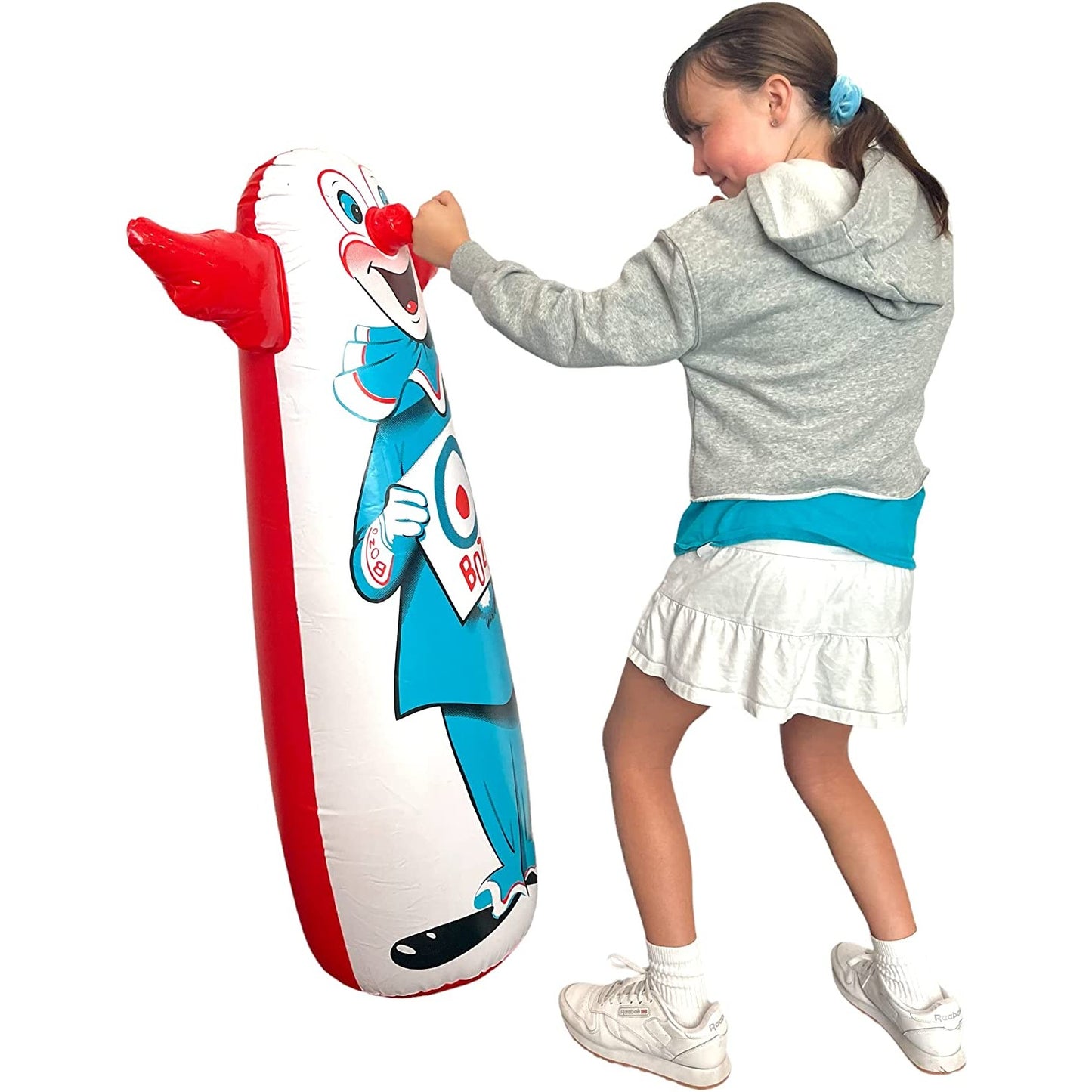 A girl is punching an original Bozo the clown bop bag.