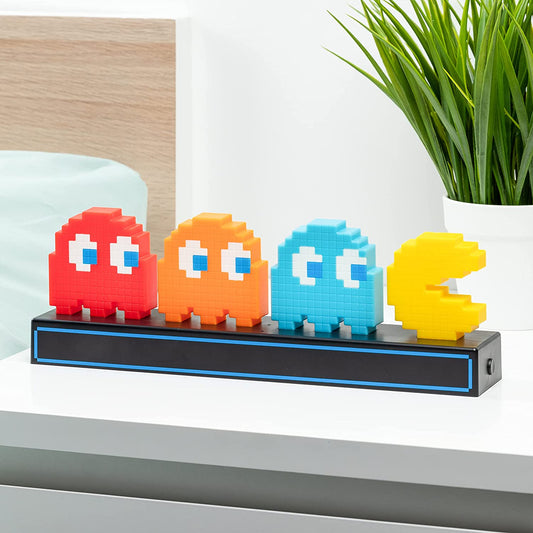 A Pac-Man with ghosts light on a bedside table.
