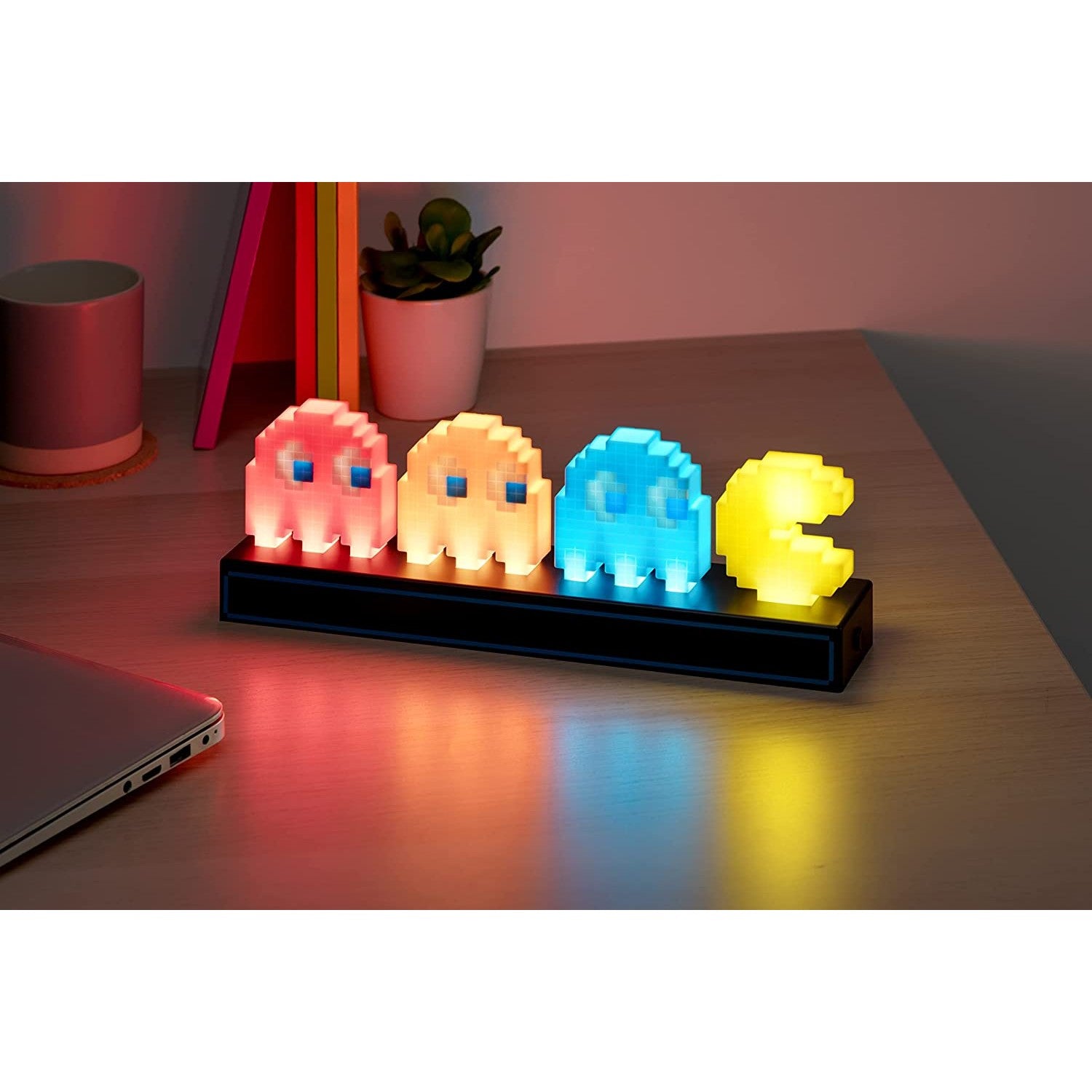 A Pac-Man with three ghosts retro-style light on a table. The lamp is switched on.