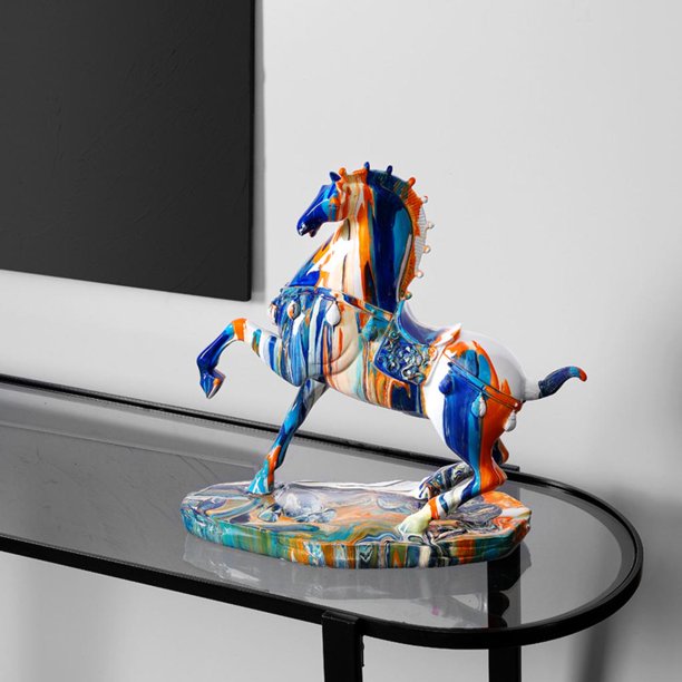 A horse figurine covered in drips of colorful paint resting on a glass table.