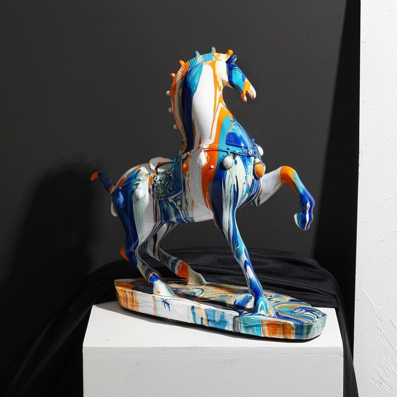 A horse figurine posed in a gallop stance and covered in colorful dripping paint.