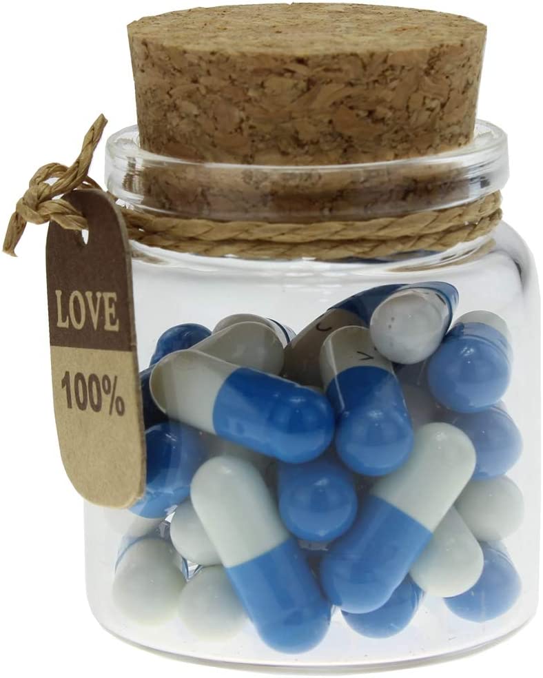 A small glass jar with dark blue and white pill capsules inside. The capsules contain love notes.