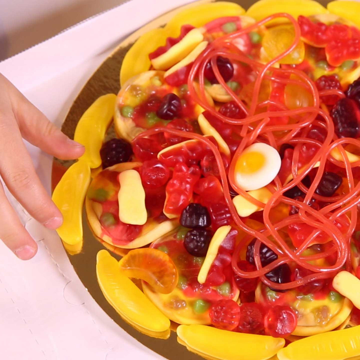 Large gummy candy pizza presented inside a pizza box