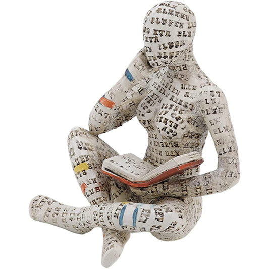 A home decor figurine of a woman with her legs crossed reading a book.