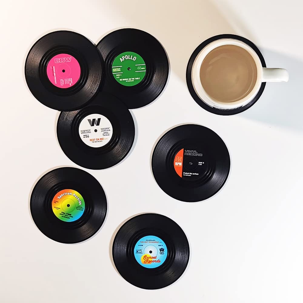 Six drink coasters shaped like vinyl records. There is also a full cup of coffee sitting on another coaster.